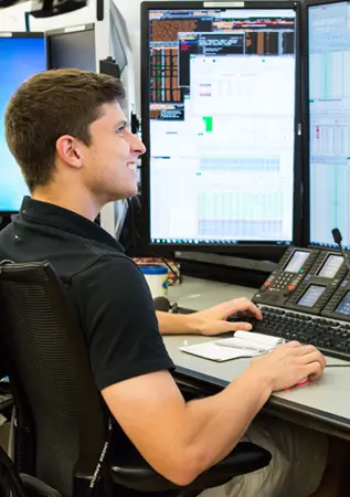 Man sitting at desk smiling at computer