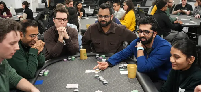 Group of people sitting at table playing poker 